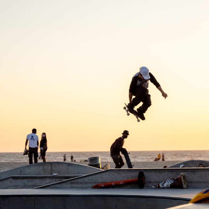 Venice Skate Park with skate boarder doing a trick during sunset