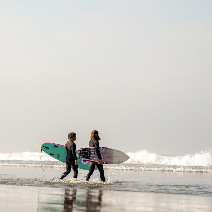 Two surfers walking into the ocean