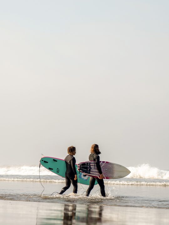 Two surfers walking into the ocean