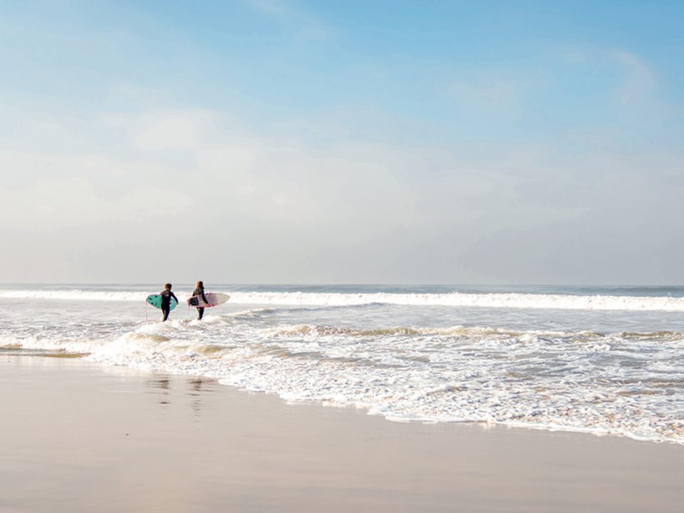 two surfers walking into the ocean