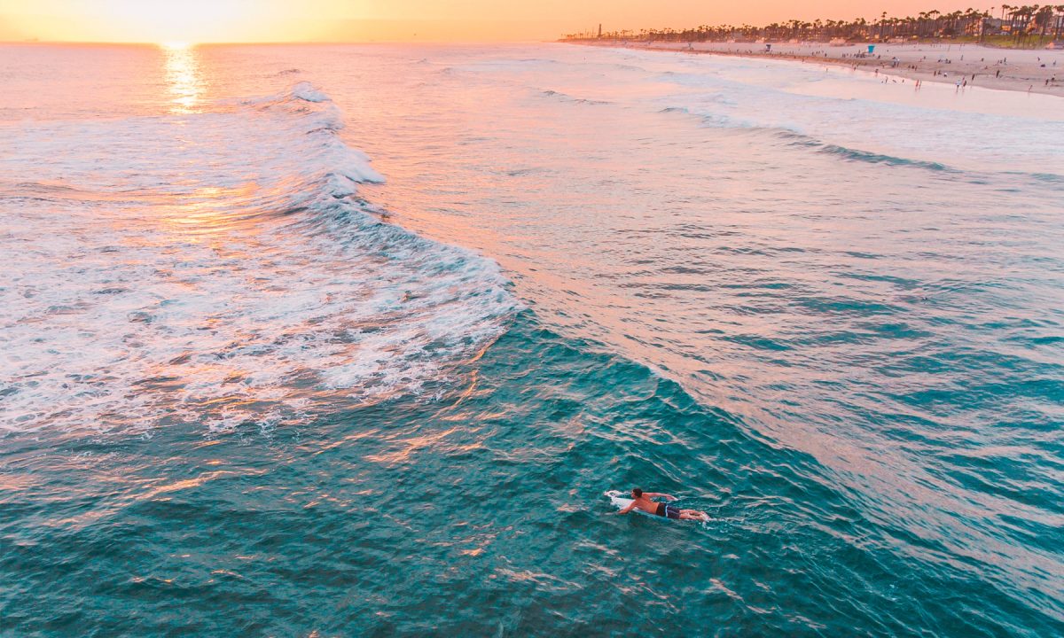 Surfer in the Pacific Ocean during sunset