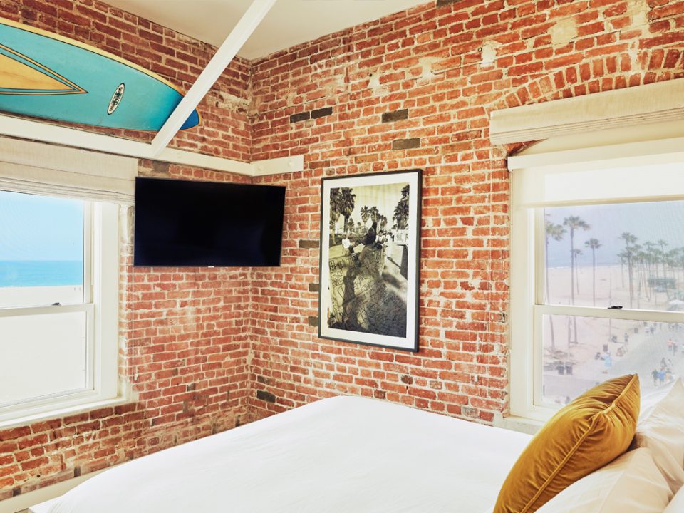 Venice V hotel room with tv, surfboard, and views of the pacific ocean and venice boardwalk