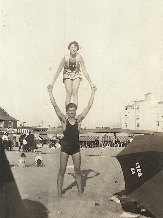 old black and white image of woman standing on shoulders of man on venice beach