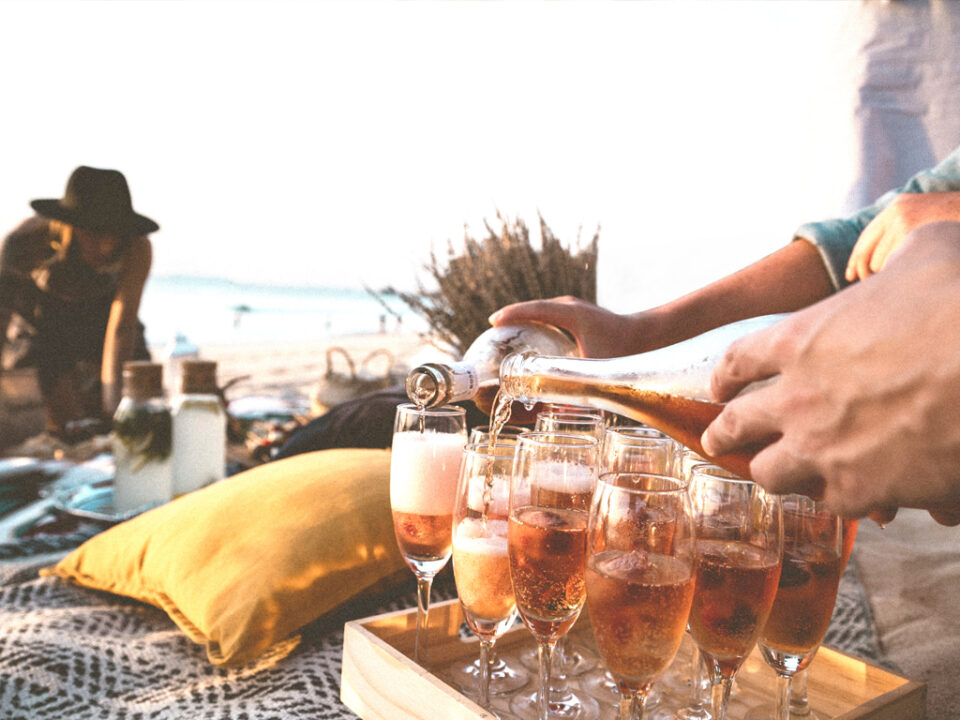 Waiter serving wine glasses on the beach