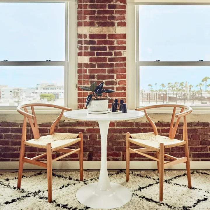 table and two chairs with window view of venice and pacific ocean.