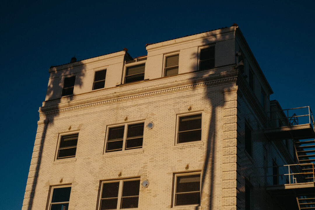 exterior of Venice V hotel with palm tree shadows